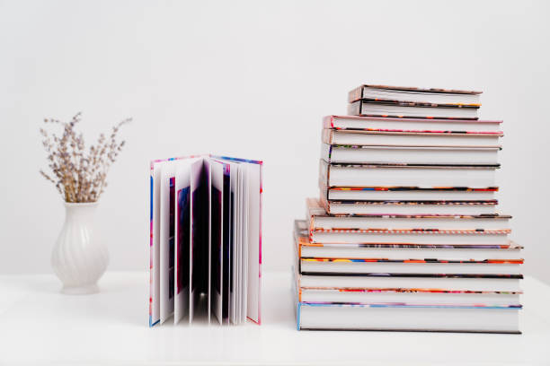 Stack of colorful books with a book standing upright next to them
