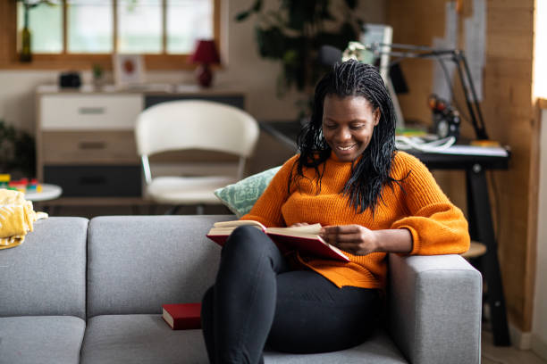 Woman sitting on a couch reading a book